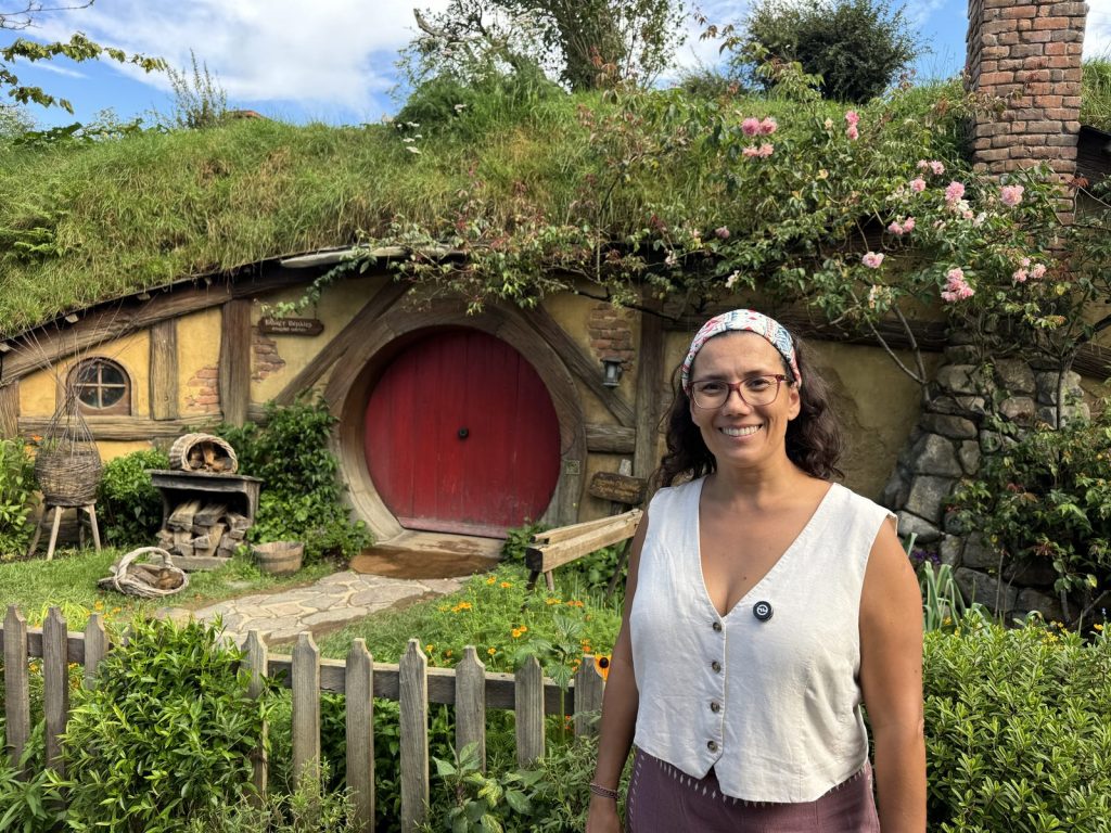 Patricia Velasco delante de una casa hobbit en Hobbiton, Nueva Zelanda