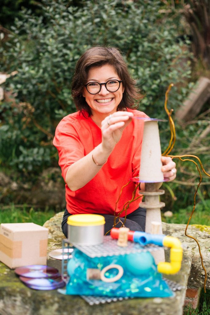 Priscilla Vela en el exterior, con materiales de juego de piezas sueltas de LaPieza