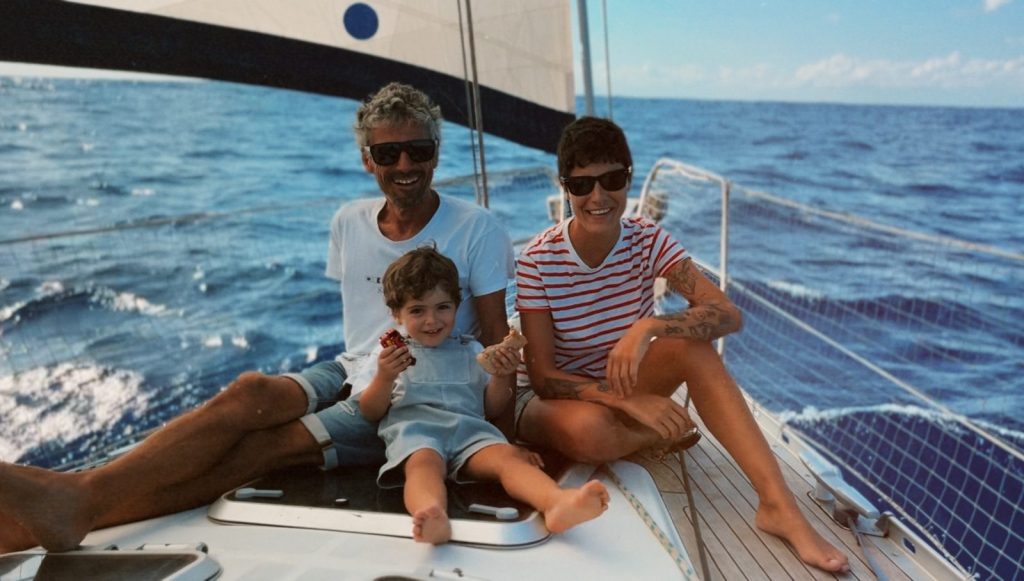 Carmen, Uri y su hijo Leo sentados en la cubierta del velero Forquilla en alta mar