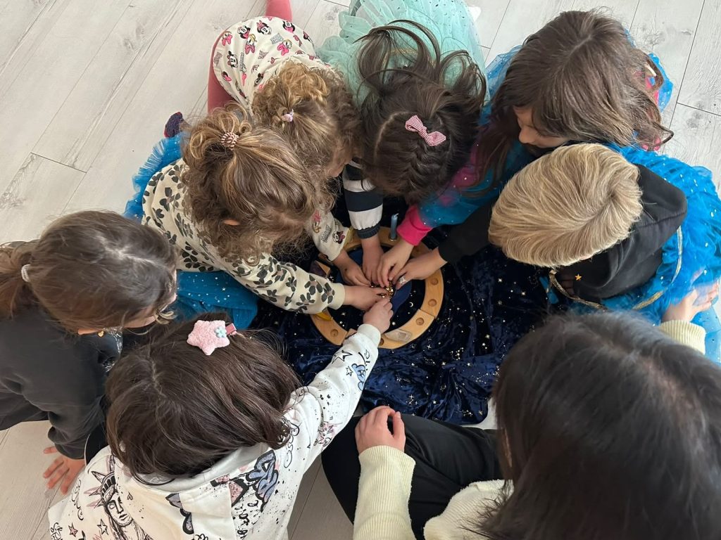 Niñas y niños en corro durante una sesión de yoga en familia